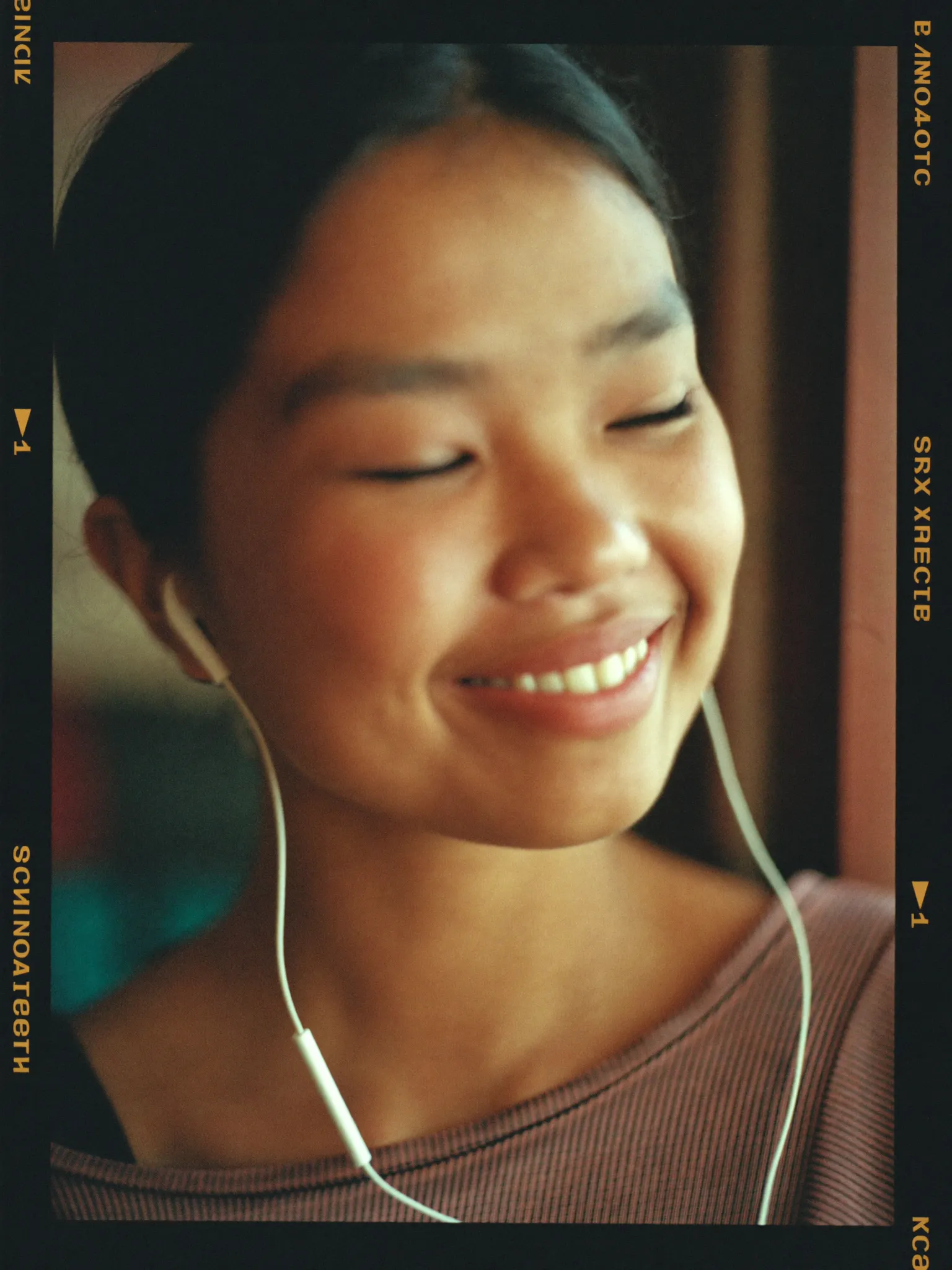 A young Nepali woman listening to a voice note, eyes closed